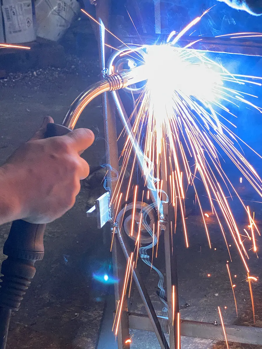 Soudure à l'arc d'un élément de ferronnerie, gerbe d'étincelles, atelier L'Art de Faire