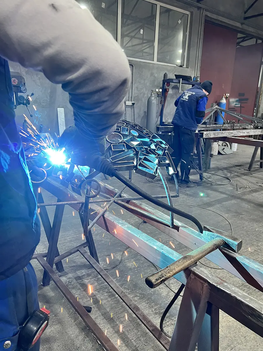 Soudure d'une sculpture sphère en métal en atelier, gerbe d'étincelles, L'Art de Faire