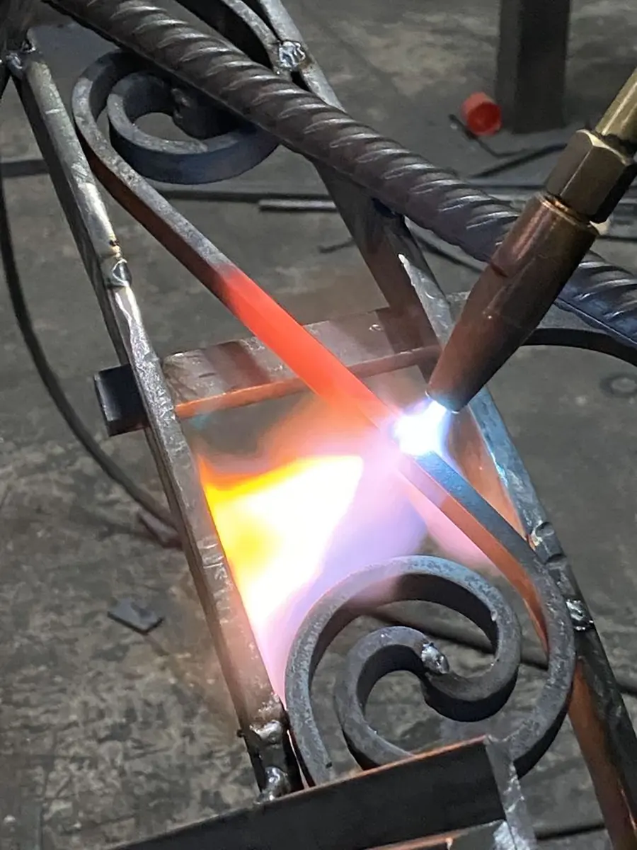 Chauffe au chalumeau d'un assemblage de volutes, atelier L'Art de Faire