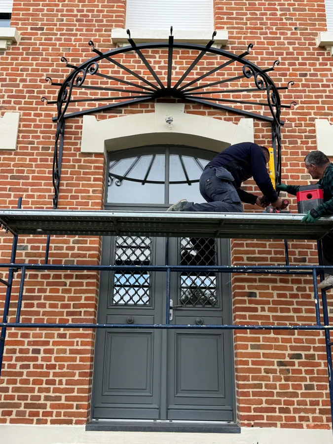 Grille et imposte cintrée en fer forgé sur une façade en brique, réalisation L'Art de Faire, ferronnerie d'art dans l'Oise