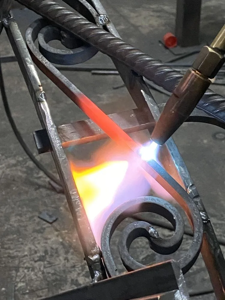 Volute en fer forgé chauffée à la flamme avant mise en forme, atelier L'Art de Faire