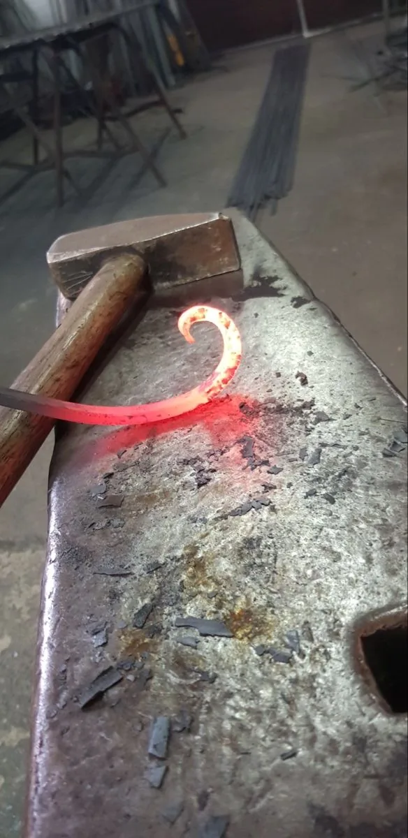 Cintrage d'une pièce en fer forgé incandescente sur l'enclume, atelier L'Art de Faire
