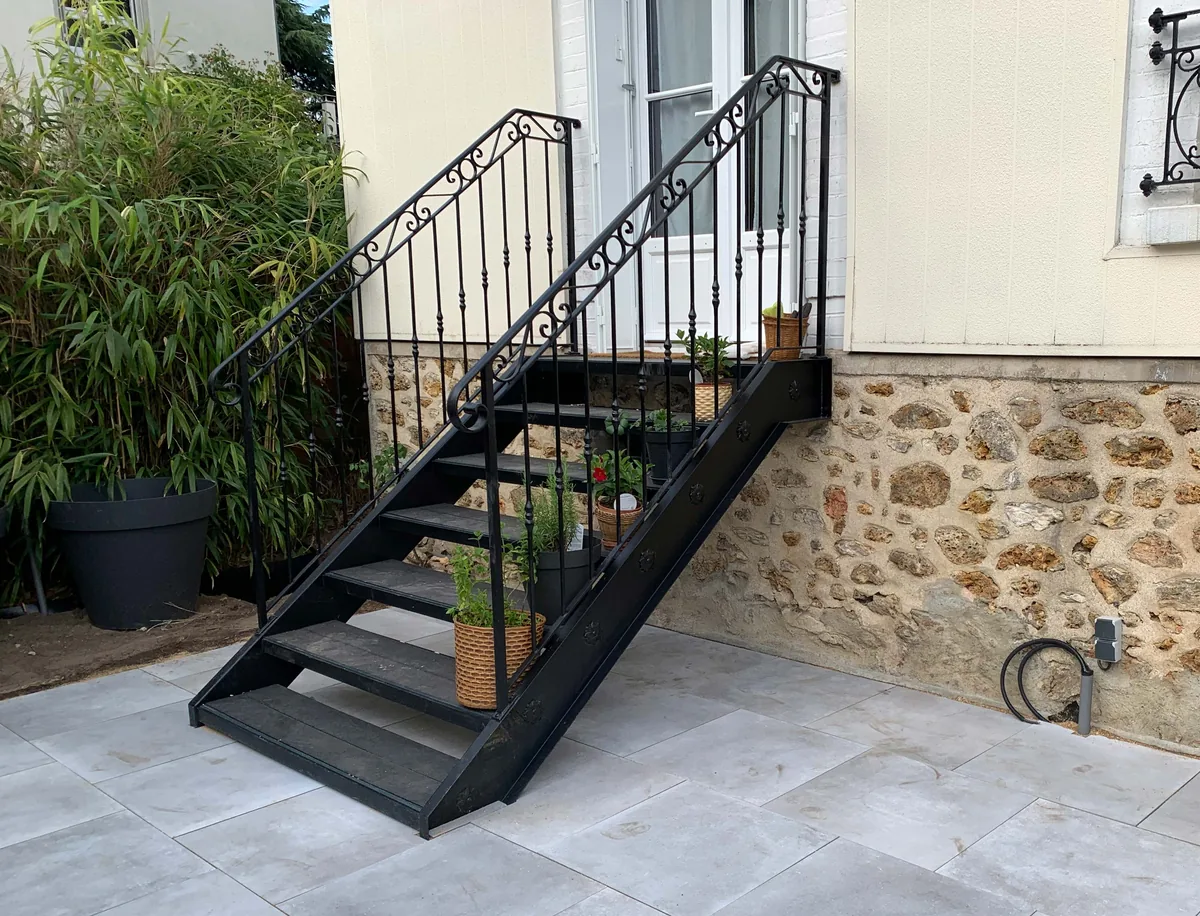 Escalier droit contemporain en fer forgé à marches épurées devant un mur en pierre, L'Art de Faire