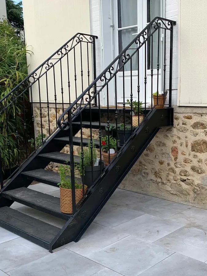 Escalier droit contemporain en fer forgé à marches épurées devant un mur en pierre, L'Art de Faire