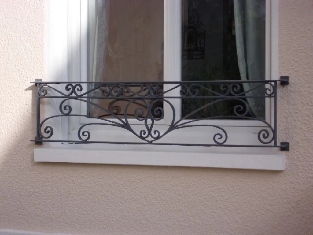 Garde-corps de fenêtre en fer forgé à volutes, façade enduite, L'Art de Faire