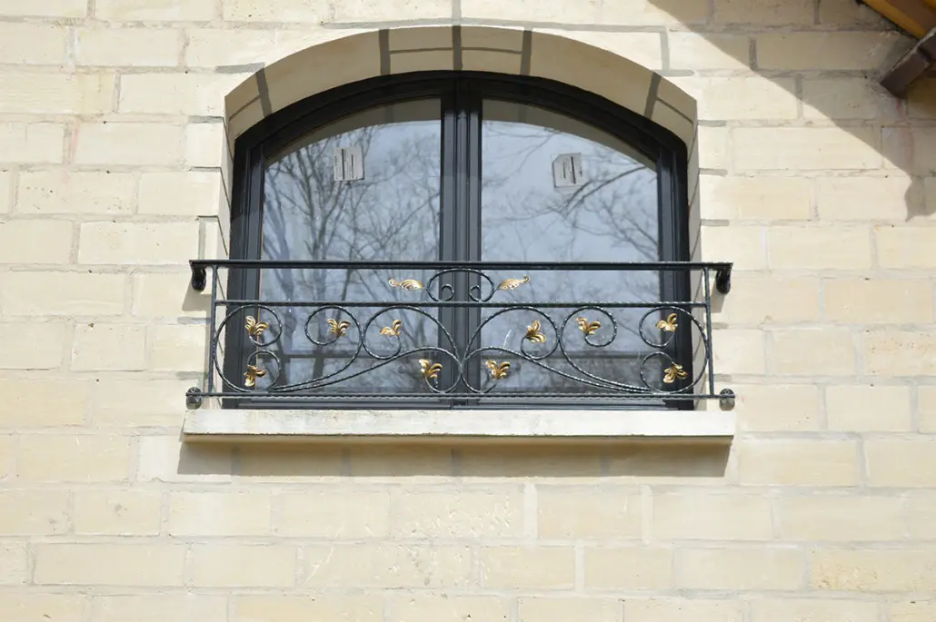Garde-corps de fenêtre en fer forgé à volutes et fleurs de lys dorées, L'Art de Faire