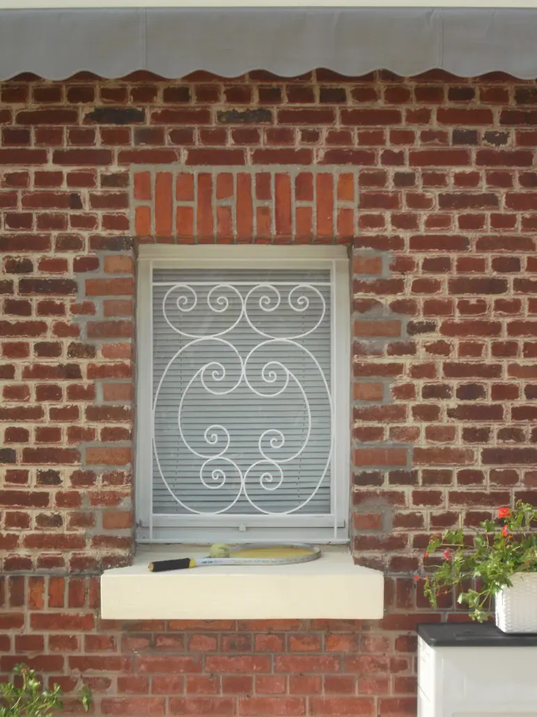 Grille de défense en fer forgé laqué blanc à volutes sur fenêtre, L'Art de Faire