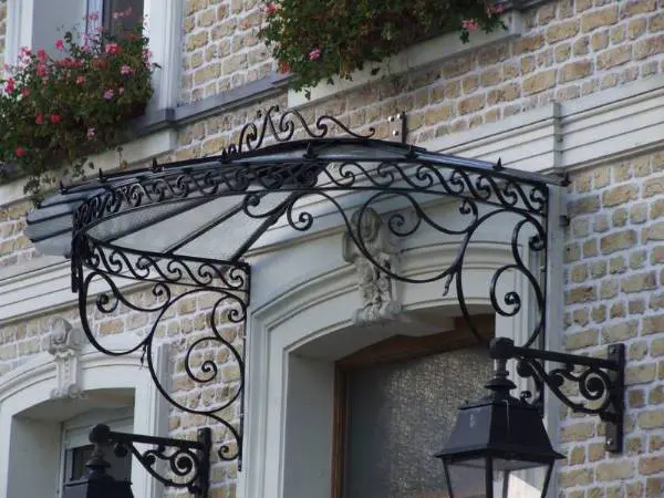 Marquise Belle Époque richement ouvragée en fer forgé sur façade en pierre, lanternes assorties, L'Art de Faire