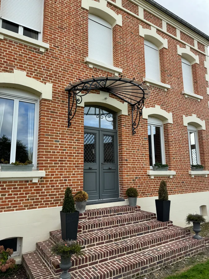 Marquise en fer forgé au-dessus d'un perron en pierre, maison en brique, L'Art de Faire