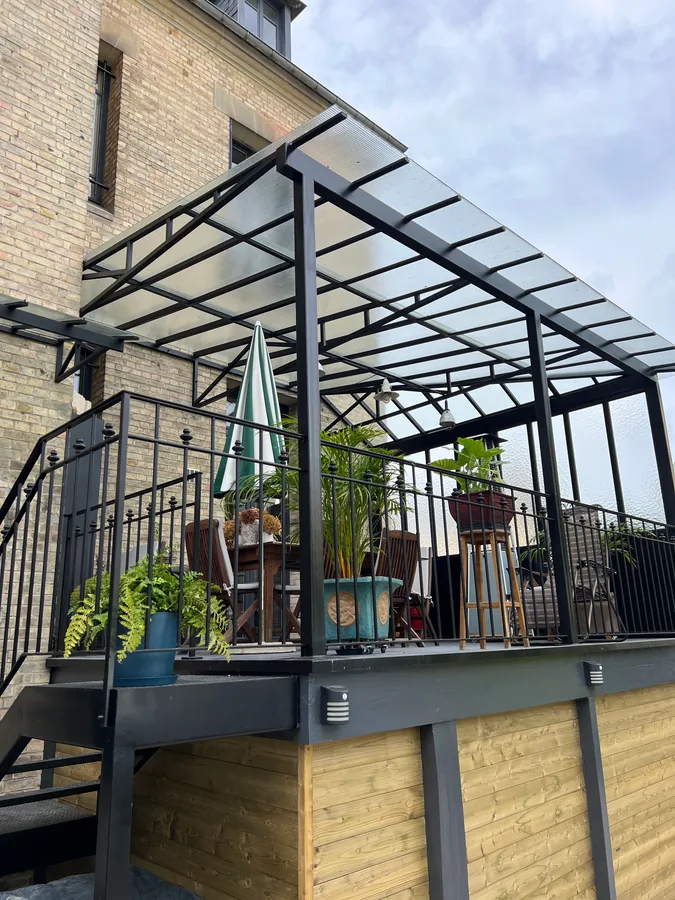 Auvent vitré sur structure en fer forgé au-dessus d'une terrasse, L'Art de Faire