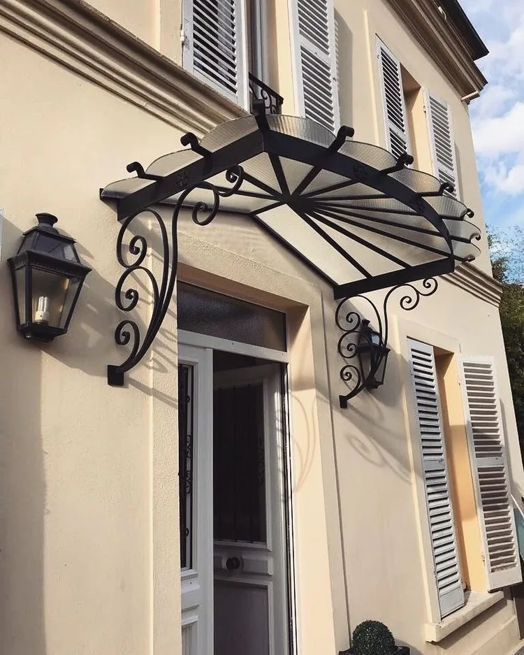 Marquise en fer forgé au-dessus d'une porte d'entrée, façade beige, L'Art de Faire