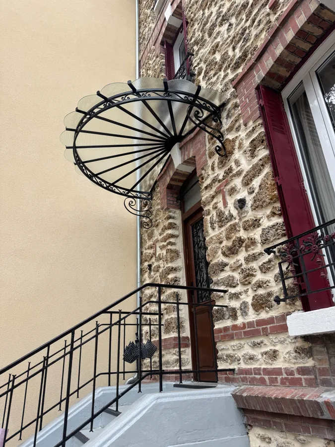 Marquise en fer forgé au-dessus d'une entrée à rampes en fer forgé, maison en pierre, L'Art de Faire