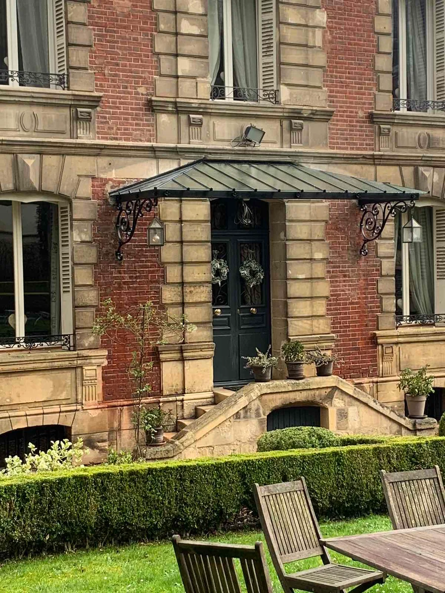 Marquise en fer forgé au-dessus d'une porte d'entrée, maison en pierre, L'Art de Faire