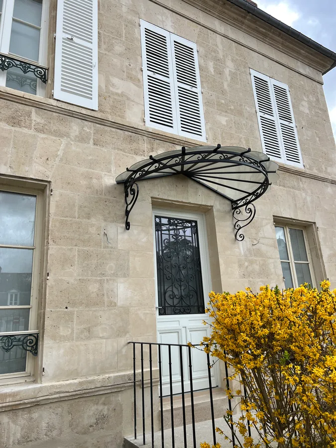 Marquise en fer forgé au-dessus d'un perron, maison en pierre, L'Art de Faire