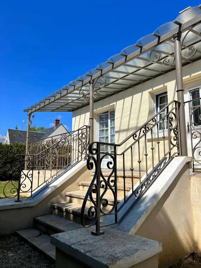 Auvent vitré en fer forgé au-dessus d'une terrasse avec garde-corps, L'Art de Faire