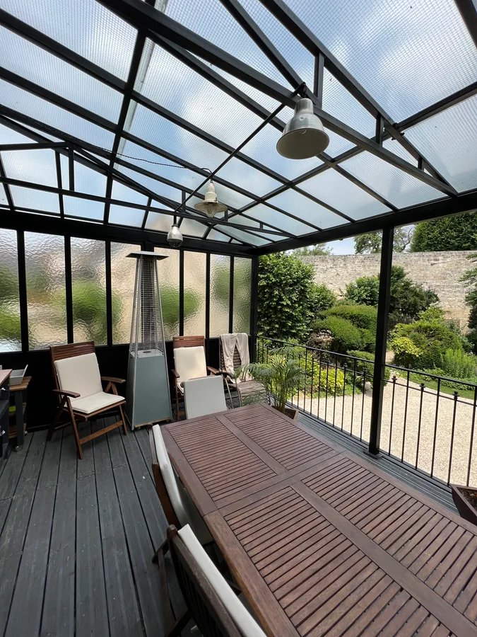 Auvent vitré en fer forgé enveloppant une terrasse, L'Art de Faire