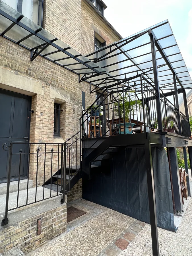 Auvent vitré en fer forgé au-dessus d'une terrasse avec perron et garde-corps, L'Art de Faire
