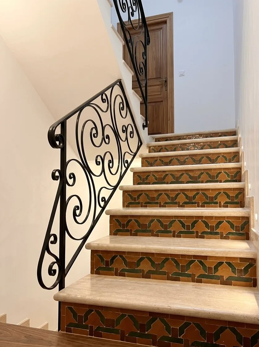 Rampe d'escalier en fer forgé à volutes, marches carrelées, L'Art de Faire